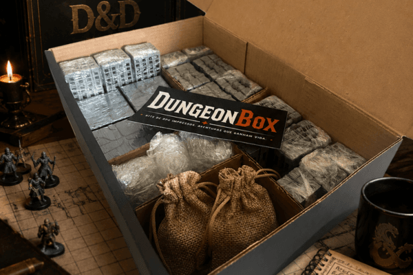Caixa DungeonBox aberta com cenários 3D modulares, miniaturas e acessórios de RPG na mesa
